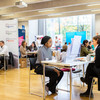 Lots of tables in a large room where people are having conversations