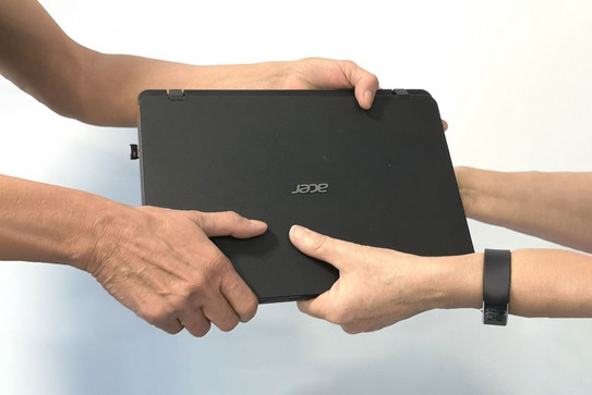 A laptop is handed over