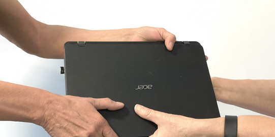 Ein Laptop wird übergeben.