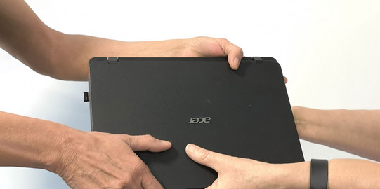 Ein Laptop wird übergeben.