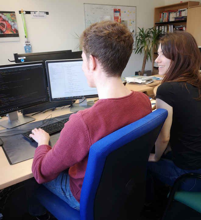 Zwei junge ITMC-Angehörige an einem Schreibtisch
