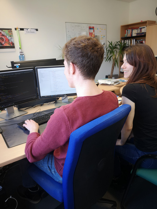 Zwei junge ITMC-Angehörige an einem Schreibtisch