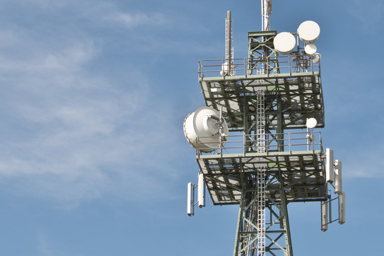 Mast with different antennas in front of a blue sky