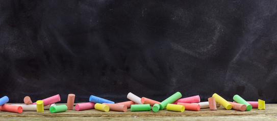 Coloured chalks in front of a black board