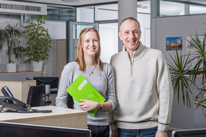 Zwei freundlich schauende Beschäftigte in einem Büro