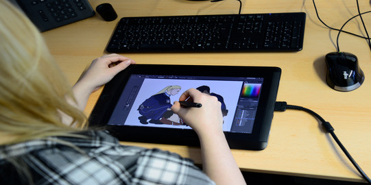Trainee is working on a graphic with a tablet