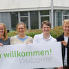 Students stand in front of the GB3 with a cordial welcome banner.