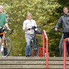 Zwei Männer und eine Frage stehen mit ihren Fahrrädern am oberen Ende einer Treppe auf dem TU-Campus.