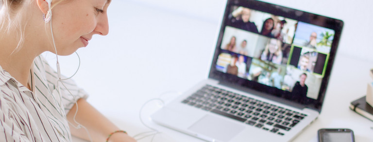 Woman sitting at laptop with zoom session.