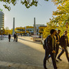 Studierende laufen über den herbstlichen Campus