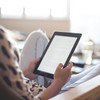 A Woman is sitting in an armchair and reading an e-book