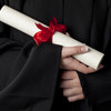 A rolled document with red bow is held by hands. 